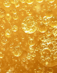 Close-up of golden bubbles of Two-Phase makeup remover a gold background