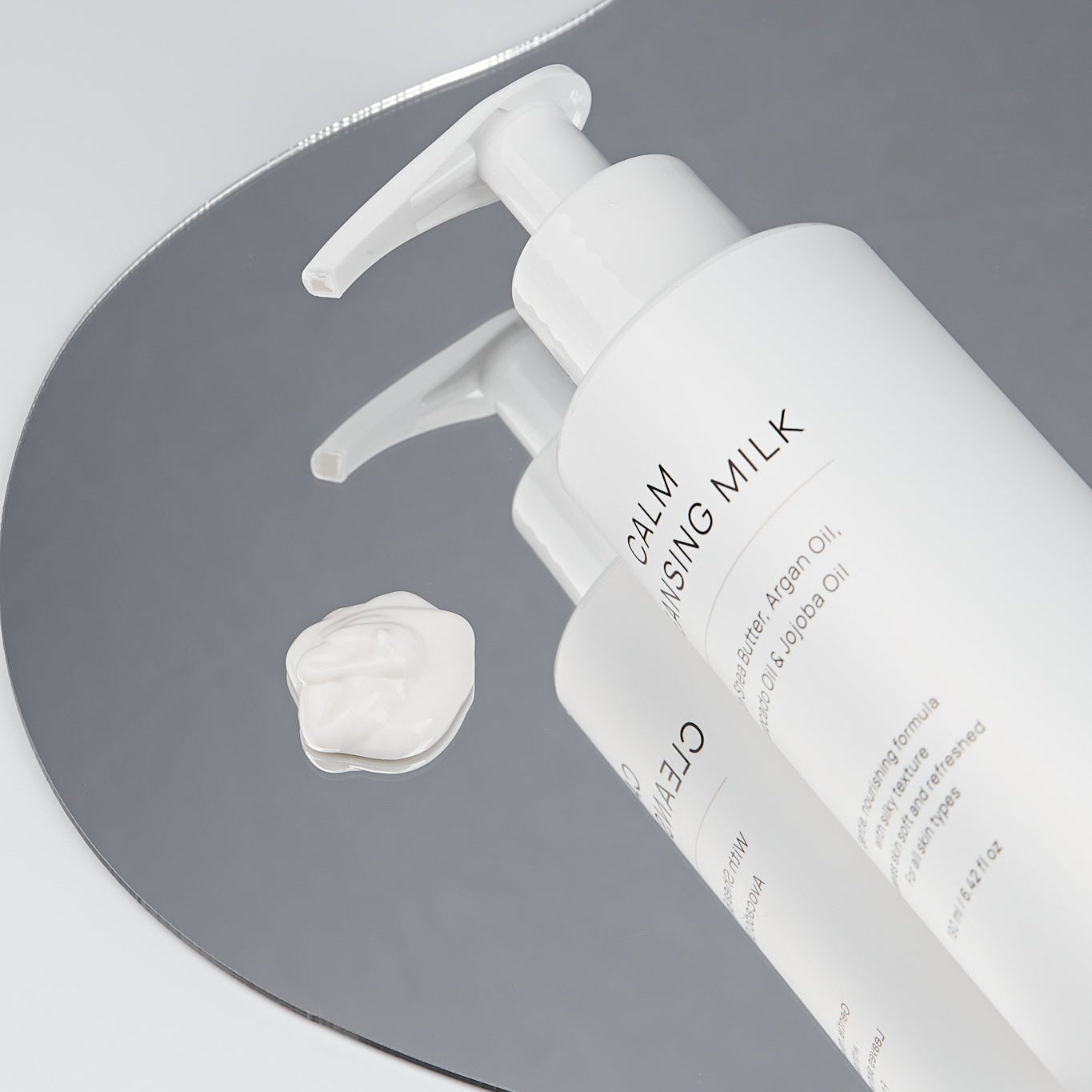 SNOA Calm Cleansing Milk with a droplet on a gray background