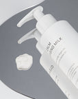 SNOA Calm Cleansing Milk with a droplet on a gray background