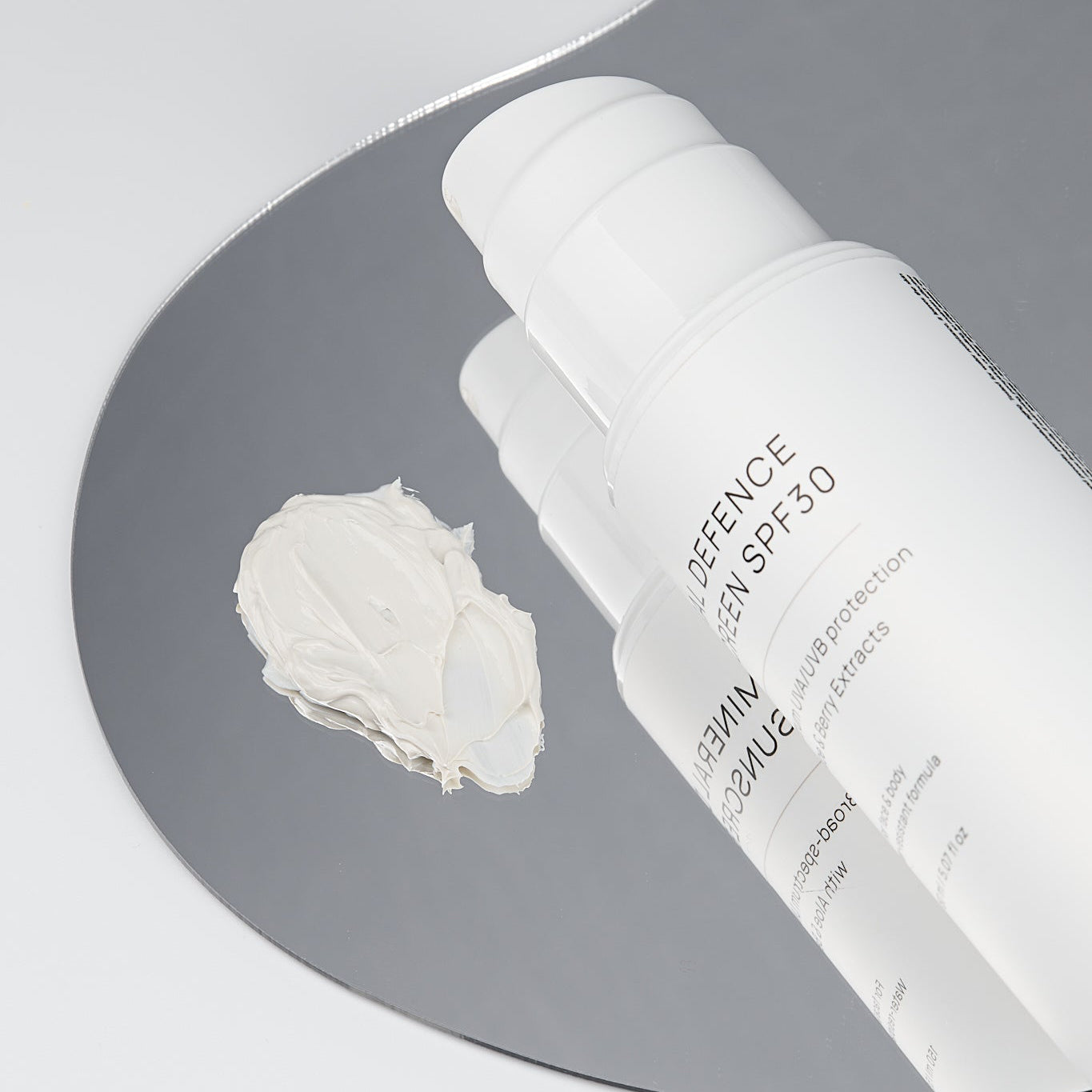 SNOA Mineral Defence Sunscreen SPF30 with a small amount of cream on a gray background