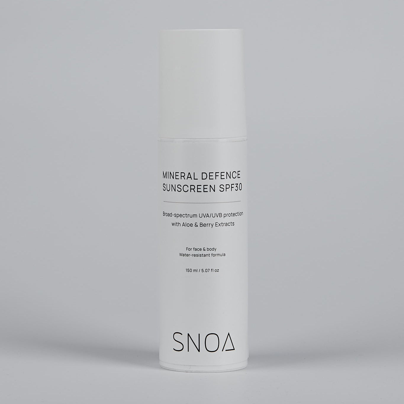 SNOA Mineral Defence Sunscreen bottle on a gray background