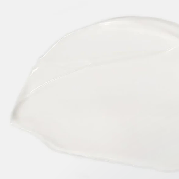White ceramic plate with Calm Cleansing milk texture on it, on a white background